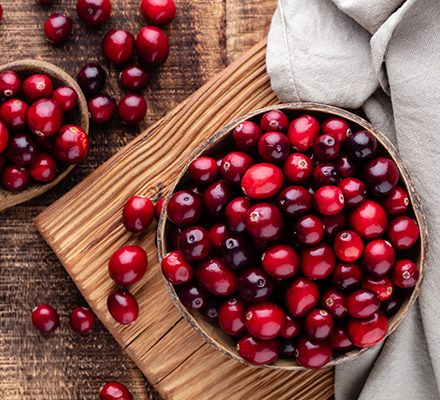 Red cranberries on wooden background. Brries in a bowl. Ripe cranberry in wooden bowl on wooden table.
