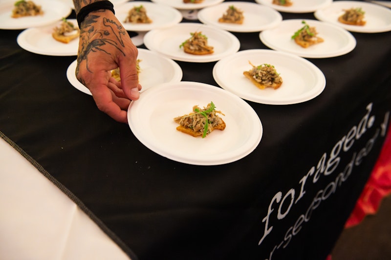 hand serving small plates of food